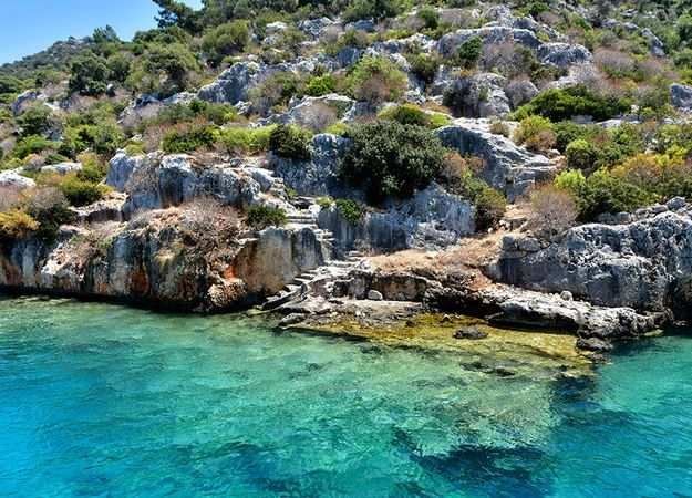 <p>Kral Koyu, yerli halk arasında çok bilinse de, hâlâ geniş kitlelerin radarına girmiş değil. Bu da burayı özel kılıyor. Kampçılar, doğa yürüyüşçüleri ve sessiz bir tatil arayanlar için mükemmel bir rota. Ancak gitmeden önce temel ihtiyaçlarınızı yanınızda götürmenizde fayda var; zira burada ticari işletme neredeyse yok denecek kadar az.</p>
<p>Antalya’nın doğusunda, kalabalıklardan uzak bir alternatif arayanlar için Gazipaşa ve özellikle Kral Koyu, görülmeye değer bir destinasyon. Eğer siz de doğayla baş başa kalmak, denizin ve güneşin tadını huzur içinde çıkarmak istiyorsanız, bu yaz rotanızı biraz daha doğuya çevirmeyi düşünebilirsiniz.</p>