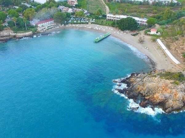 <p><strong>4. Bozyazı</strong></p>
<p>Anamur’a komşu olan Bozyazı, Mersin’in gözlerden uzak köşelerinden biri. Trafik yok, yüksek binalar yok, gürültü neredeyse hiç yok. Evinizin balkonundan denizi izleyip, akşamları sokakta yürüyüş yapabileceğiniz kadar sade ve samimi bir ilçe. Yaşlı nüfus oranı oldukça yüksek çünkü insanlar buraya huzur için göç ediyor.</p>
<p><strong>5. Mut</strong></p>
<p>Torosların kucağında yer alan Mut, Mersin’in denizden uzak ama doğaya en yakın ilçelerinden biri. Zeytinlikler, ceviz bahçeleri, geleneksel pazarları ve sessiz sokaklarıyla tam bir iç huzuru sunuyor. Yaz aylarında bile aşırı sıcak olmaz, çünkü rakımı biraz yüksektir. Gölgesinde kitap okunacak ağaç bol, vakit geçirecek telaş yok.</p>