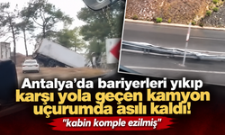 Antalya'da bariyerleri yıkıp karşı yola geçen kamyon uçurumda asılı kaldı! "kabin komple ezilmiş"
